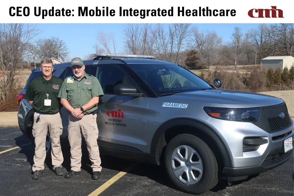 Two men standing in front of a vehicle